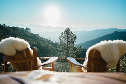 uma mesa com cadeiras com vista para as montanhas em Chalé europeu com vista infinita e cinema em C. do Jordão em Campos de Jordão