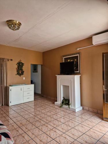 a living room with a fireplace and a tv at Casa Gracia in Jamay