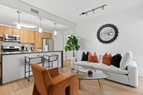 a living room with a couch and a table at Amethyst Horizon - Stylish peaceful 2BR w zen Garden View Pool Gym in Los Angeles