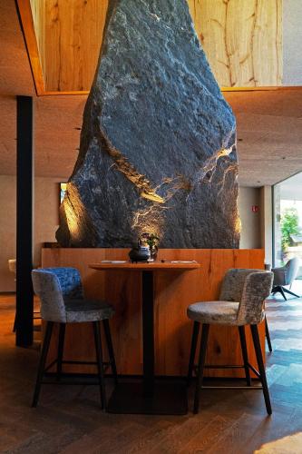 a dining room with a table and two chairs at La Tambra - Hotel Lodge in Santa Cristina in Val Gardena