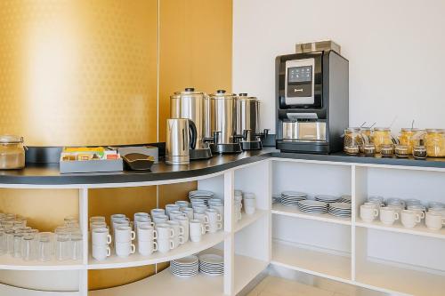 a kitchen with a coffee maker and a microwave at Fueguino Hotel in Ushuaia