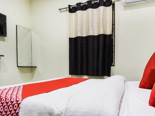 a bedroom with a red and white bed and a window at Hotel O S&h Residency Bahadalpur Railway Station in Khandagiri
