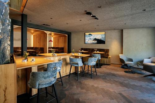 サンタ・クリスティーナ・ヴァルガルデーナにあるLa Tambra - Hotel Lodgeのバー(椅子、テーブル付)