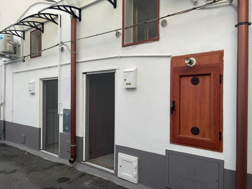 a white building with a wooden door and windows at MINI HOUSE in Montescaglioso