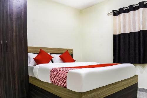 a bedroom with a bed with red pillows at Hotel O S&h Residency Bahadalpur Railway Station in Khandagiri