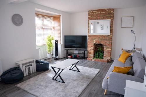 a living room with a couch and a fireplace at Modern 3 Bed Bromley, Chislehurst House - with parking in Chislehurst