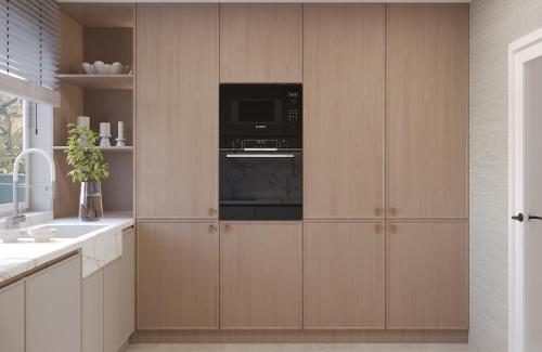a kitchen with wooden cabinets with a microwave at StOliva RESIDENCES Bay pearl 