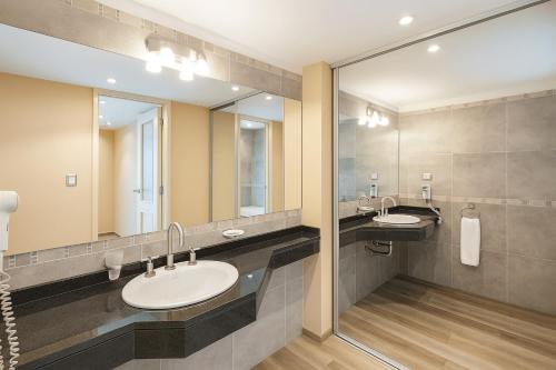 a bathroom with two sinks and a large mirror at Fueguino Hotel in Ushuaia