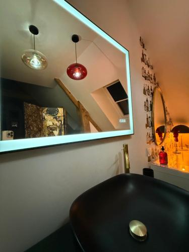 ein Badezimmer mit einem schwarzen Waschbecken und einem Spiegel in der Unterkunft Ecrin de Charme in Granville