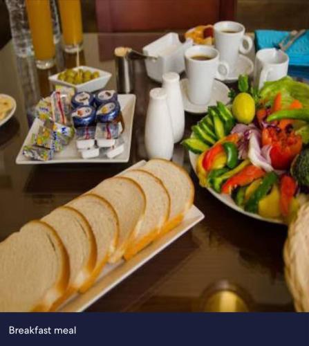 a table with two plates of food with bread and fruit at Italia Hotel cairo in Cairo