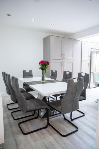 a dining room with a white table and chairs at Modern 3 Bed Bromley, Chislehurst House - with parking in Chislehurst