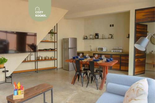 a living room with a table and a kitchen at Estancia intima con terraza en Oaxaca Pet Friendly in Oaxaca City