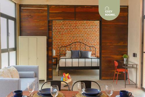 a living room with a bed in a brick wall at Estancia intima con terraza en Oaxaca Pet Friendly in Oaxaca City