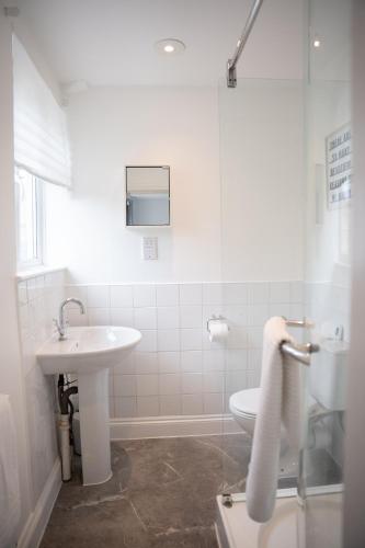 a white bathroom with a sink and a shower at Modern 3 Bed Bromley, Chislehurst House - with parking in Chislehurst