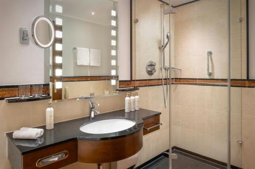 a bathroom with a sink and a shower at Arabella Jagdhof Resort am Fuschlsee, a Tribute Portfolio Hotel in Hof bei Salzburg