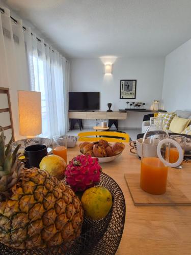a dining room table with fruit and juice on it at AQUAWAVES - Appartement T2 CARLA SUN - Saint-François in Saint-François