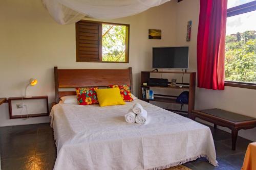 a bedroom with a bed with two towels on it at Pousada Aquarela in Morro de São Paulo