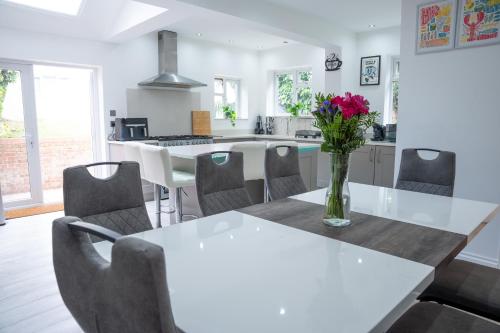 a kitchen with a table with a vase of flowers on it at Modern 3 Bed Bromley, Chislehurst House - with parking in Chislehurst