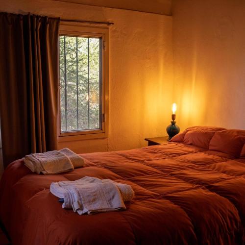 a bedroom with a bed with two towels on it at Posada de Nono in Nono