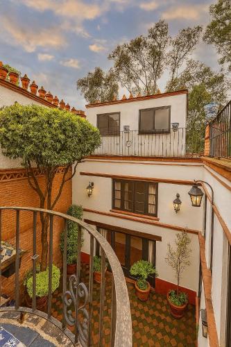 an apartment building with a balcony with a tree at Villa Colonial Centro de Coyoacán in Mexico City