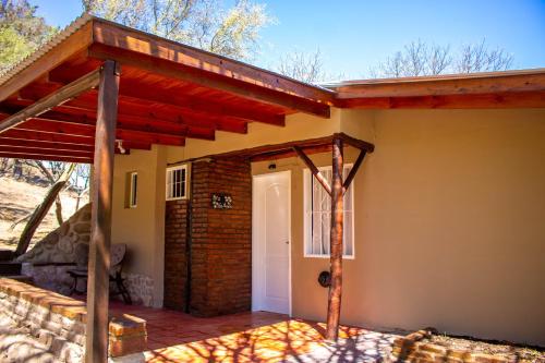 a house with a porch and a white door at Posada de Nono in Nono