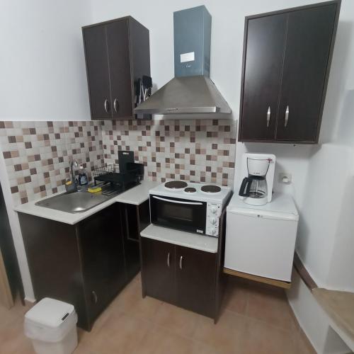 a small kitchen with a stove and a sink at Porto Mesta Residence in Liménas