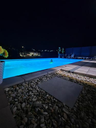a swimming pool lit up at night at Apartmani City ES in Cazin