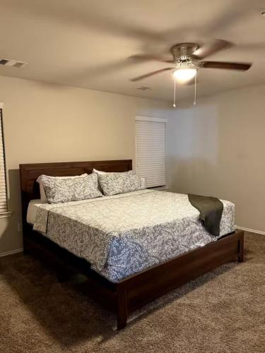 a bedroom with a bed and a ceiling fan at Katy's five bedrooms home away from home! in Katy