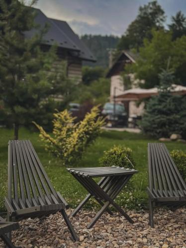 two benches sitting next to a yard with a house at Апартаменти БАРВА in Beloberëzka