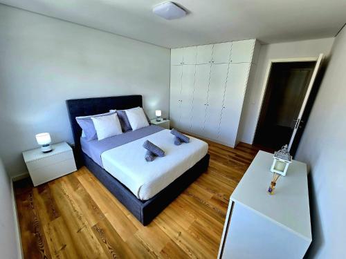 a bedroom with a bed and a white cabinet at Lagoa Nest in Lagoa