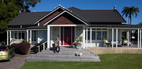 a woman standing in front of a house with a dog at HomeWell in Ohauiti