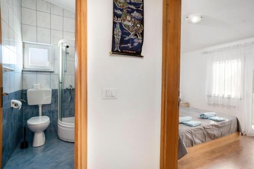 une salle de bain avec toilettes et douche et un lit dans l'établissement Apartment Draga, à Vir