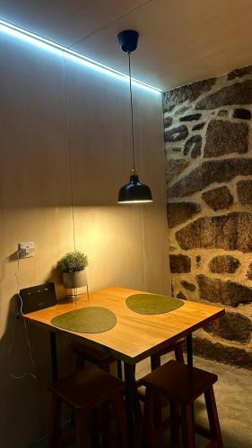 a wooden table with chairs and a potted plant on it at Casa do Doutor - Palheiro in Mondim de Basto