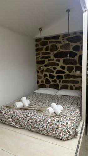 a bed with two pillows and towels on it at Casa do Doutor - Palheiro in Mondim de Basto