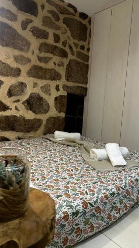 a bed in a room with a stone wall at Casa do Doutor - Palheiro in Mondim de Basto