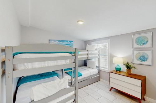 een slaapkamer met twee stapelbedden en een bureau bij Flip Flop Cottage in Rockport