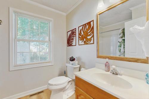 ein Badezimmer mit Toilette, Waschbecken und Spiegel in der Unterkunft Maplewood --- 17 Tulane Dr - Ohana House in The Plantations