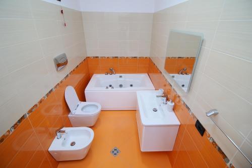 a bathroom with two sinks and a toilet and a tub at The Blue House in Široka