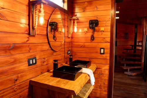 カンポス・ド・ジョルドンにあるChalé Boutique- Spa Campos do Jordãoの木製バスルーム(シンク、鏡付)