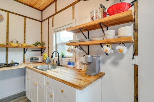 a kitchen with white cabinets and a sink and wooden shelves at Near Twilight Sites and Scenic Hikes Forks Apt in Forks