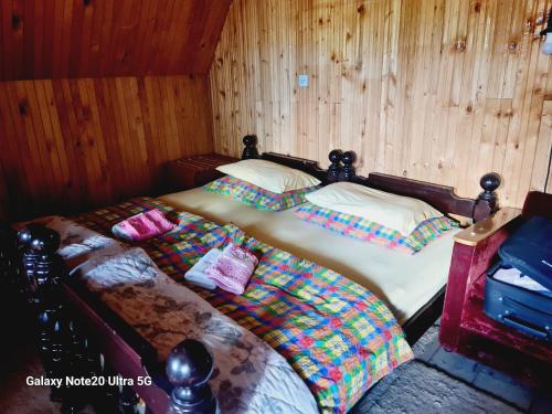 two twin beds in a room with wooden walls at Seoski dom in Šavnik