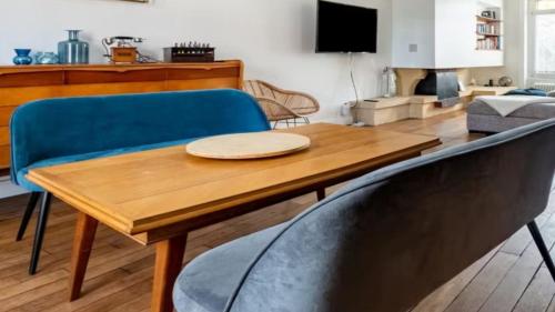 a living room with a wooden table and blue chairs at Alpine Reither Retreat Kitzbuhel in Kitzbühel