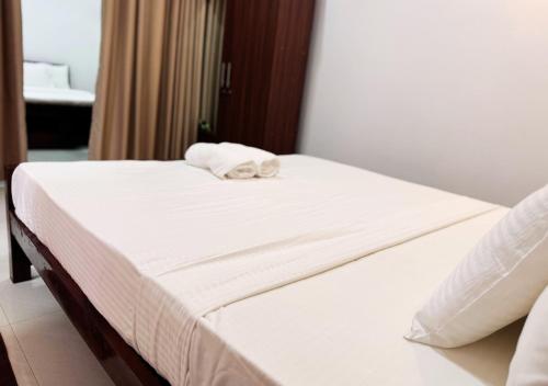 a bed in a hotel room with a towel on it at Kings Town Hotel in Anuradhapura