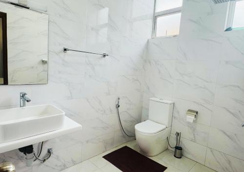 a white bathroom with a sink and a toilet at Kings Town Hotel in Anuradhapura
