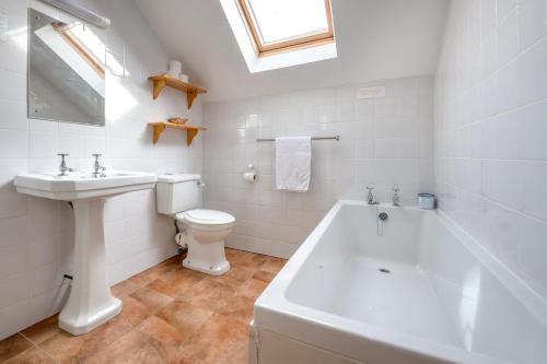 a bathroom with a sink and a toilet and a bath tub at Bragdy Wern in Llanbedrog