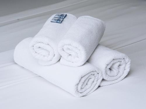 a pile of white towels on a bed at Canal House Inn in Amsterdam