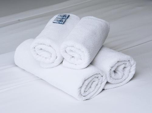 una pila de toallas blancas en una cama en Canal House Inn, en Ámsterdam