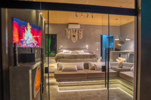 a bedroom with a bed and a tv in it at Chalé Boutique - Spa - Sauna seca , Jacuzzi , Rede suspensa in Campos do Jordão