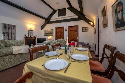 a dining room with a table and a living room at The Cottage in Llanbedrog