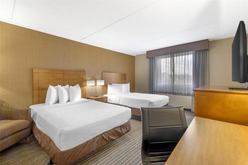 a hotel room with two beds and a flat screen tv at Best Western Royal Plaza Hotel and Trade Center in Marlborough